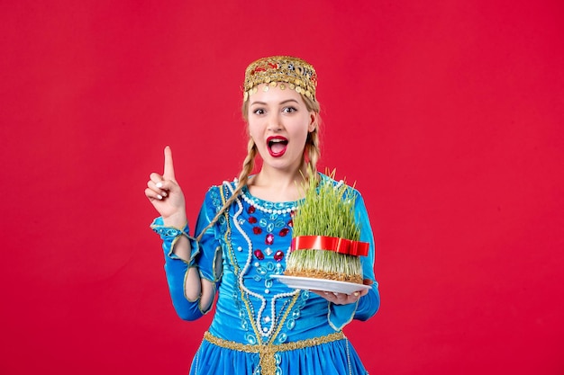 Portret van azeri vrouw in traditionele kleding met semeni studio shot rode achtergrond concept etnische lente novruz