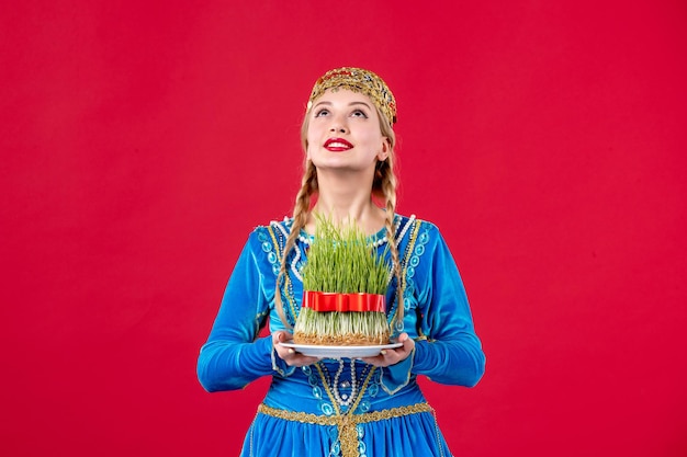 Portret van azeri vrouw in traditionele kleding met semeni studio shot rode achtergrond concept etnische vakantie lente