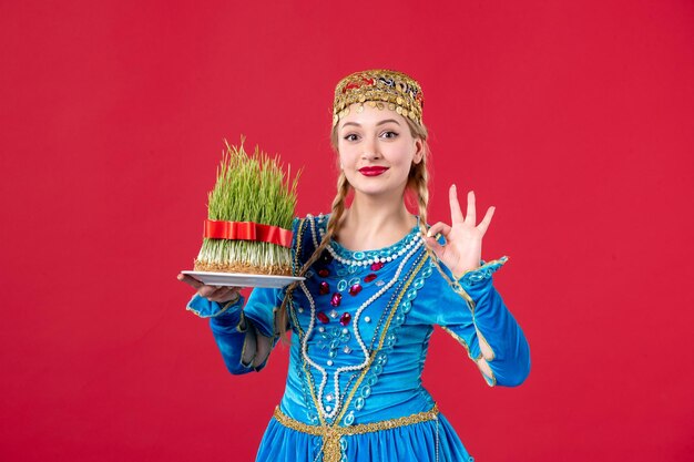 Portret van azeri vrouw in traditionele kleding met semeni studio shot rode achtergrond concept lente dansers novruz