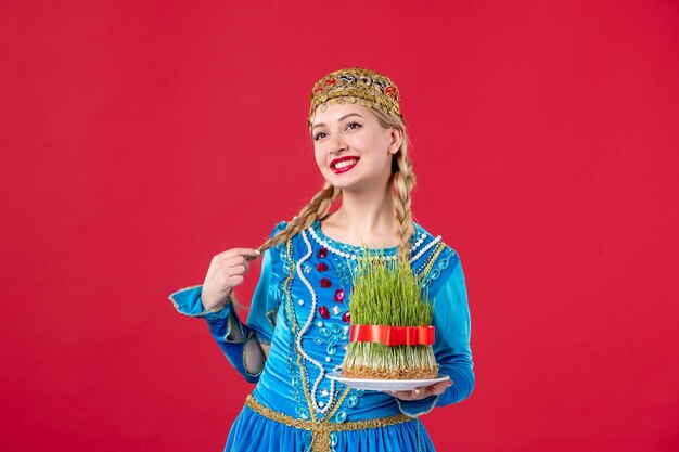 Portret van azeri vrouw in traditionele kleding met semeni studio shot rode achtergrond danser lente novruz