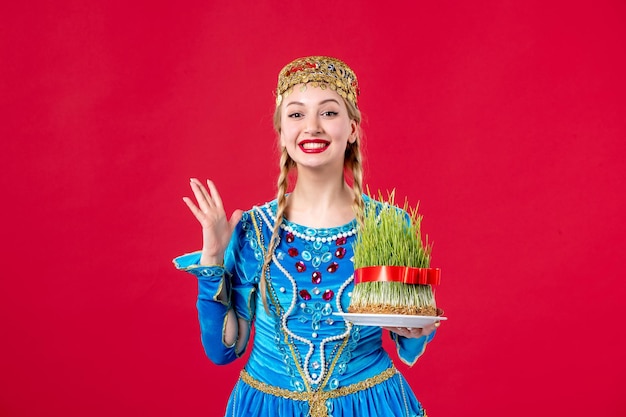 Portret van azeri vrouw in traditionele kleding met semeni studio shot rode achtergrond lente etnische novruz concept