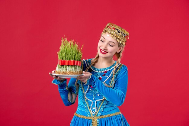 Portret van azeri vrouw in traditionele kleding met semeni studio shot rode achtergrond novruz concept danser