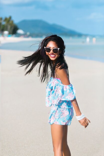 portret van Aziatisch Thais meisje met zonnebril en bloemkleding die pret op tropisch strand hebben