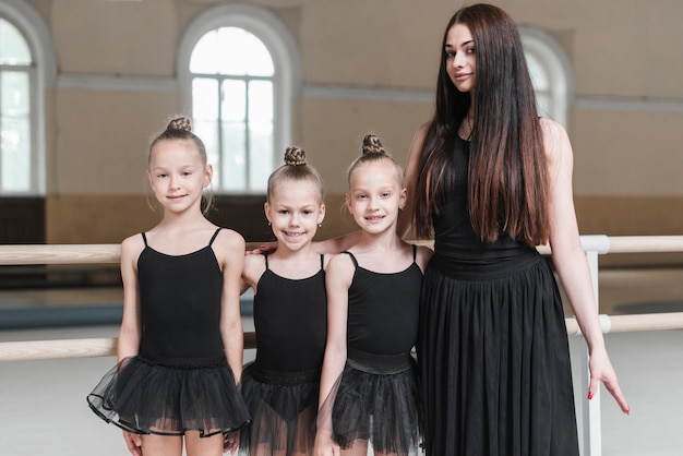 Gratis foto portret van ballerinareraar met haar student drie in dansstudio