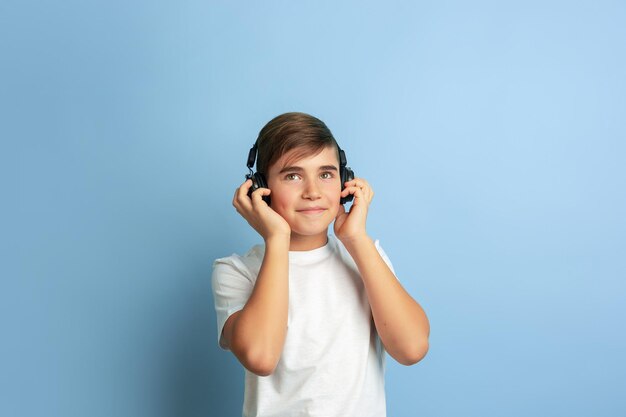 Portret van blanke tiener geïsoleerd op blauwe studio