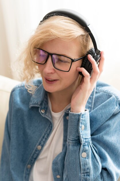 Portret van blonde vrouw die aan muziek luistert