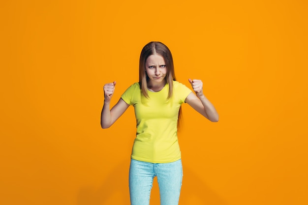 Portret van boos tienermeisje op een oranje muur