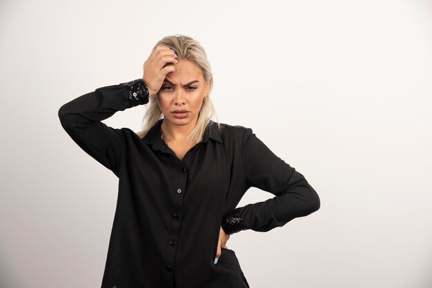 Portret van boos vrouw in zwart shirt poseren op witte achtergrond. Hoge kwaliteit foto