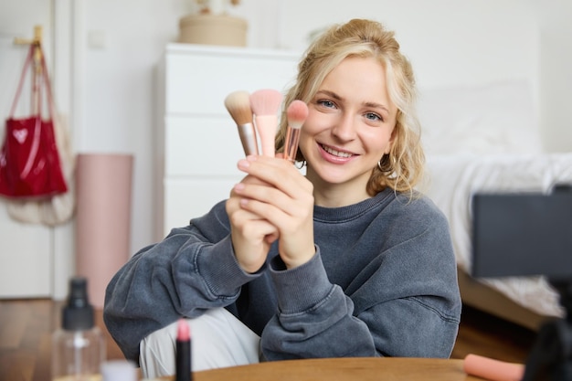 Portret van content media creator blogger zit in haar kamer en neemt video op van haar favoriete make-up