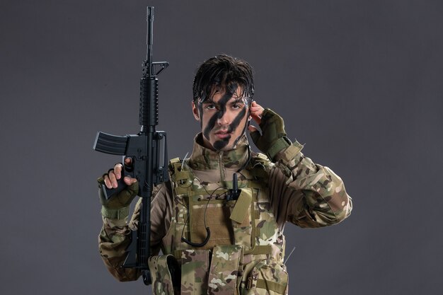 Portret van dappere soldaat die vecht tijdens operatie op donkere muur
