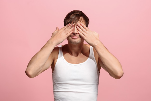 Portret van de bang man op roze muur