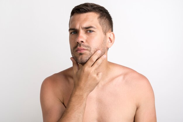 Portret van de ernstige jonge mens die en camera stellen bekijken