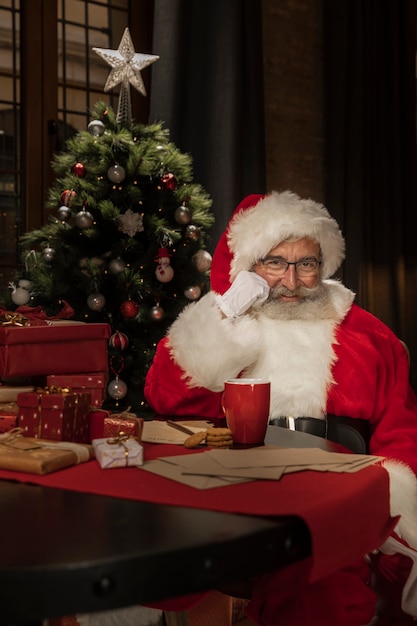 Portret van de kerstman aan de tafel