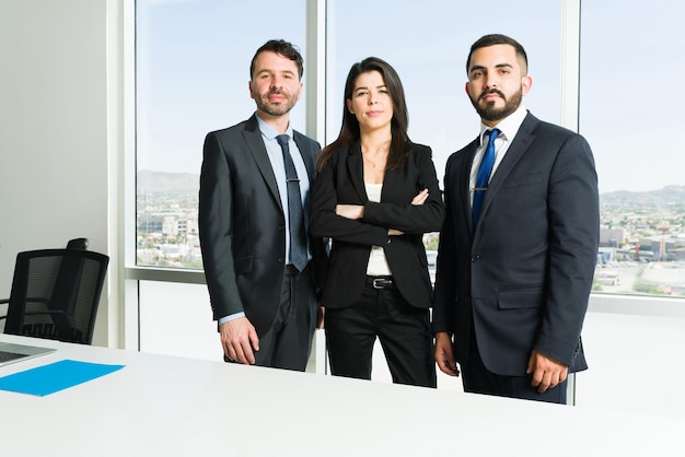Portret van drie professionele advocaten in pakken die oogcontact maken. Drukke zakenlieden en vrouwelijke baas werken samen om collaboratief teamwerk te maken