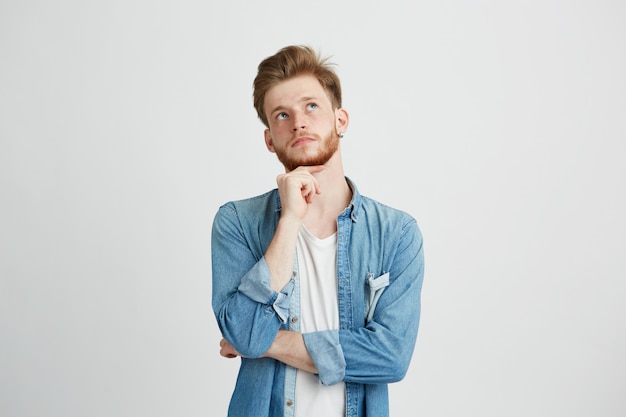 Portret van dromerige jonge knappe jongen denken dromen met de hand op de kin.