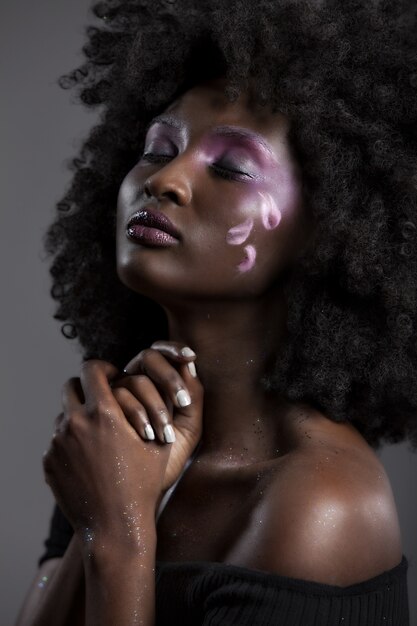 Portret van een aantrekkelijke Afro-Amerikaanse vrouw met mooie make-up poseren met haar ogen dicht