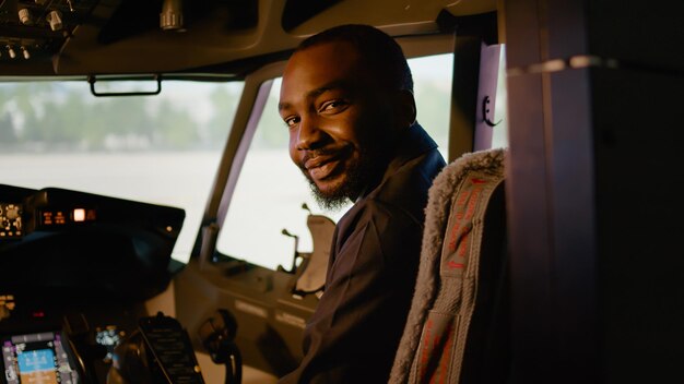 Portret van een afro-amerikaanse copiloot die in de cockpit van het vliegtuig zit met kapitein, klaar om te vliegen met het dashboard van het bedieningspaneel. Navigatiecommando met motor in cabine.