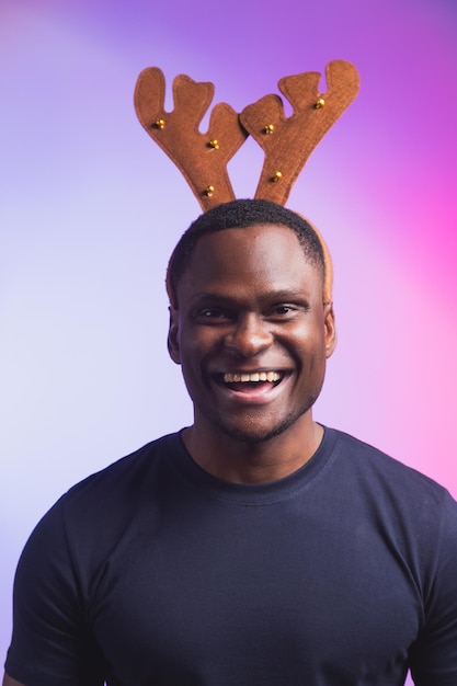 Portret van een afro-amerikaanse man draagt rudolph hertenhoorns en geniet van zijn accessoire voor kerstavond Premium Foto