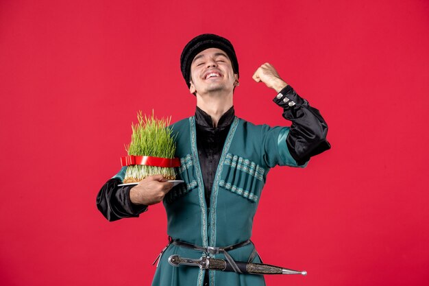 Portret van een azeri-man in traditionele klederdracht met semeni-studio-opname met rode novruz-artiest, lentedansers