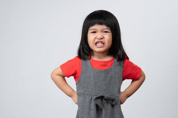Portret van een aziatisch boos en verdrietig meisje op een witte geïsoleerde achtergrond de emotie van een kind