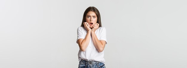 Portret van een bange en met afschuw vervulde jonge vrouw die hijgt en er bang uitziet