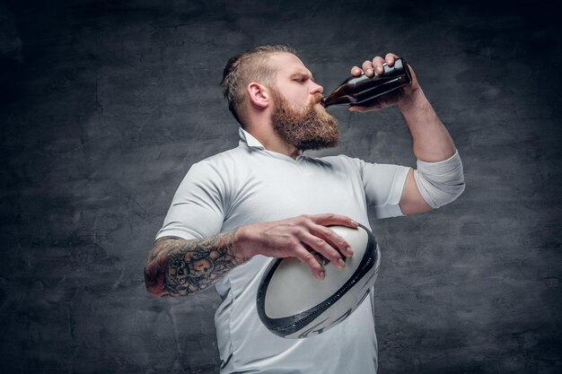 Portret van een bebaarde rugbyspeler met tatoeages op zijn armen