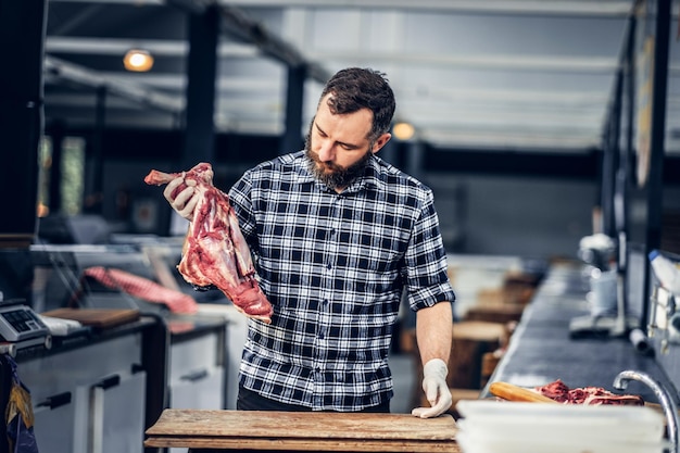 Portret van een bebaarde slager in een slagerij