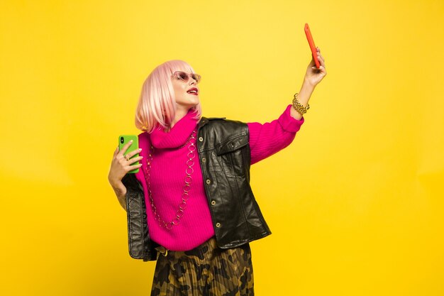 Portret van een blanke vrouw geïsoleerd op gele studio achtergrond, influencer zijn zoals