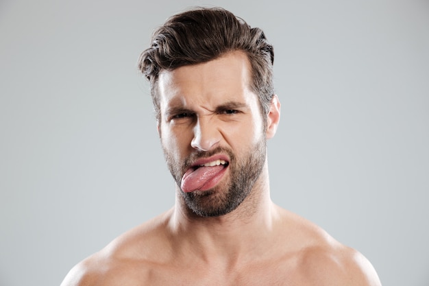 Portret van een boos geïrriteerde naakte bebaarde man met tong