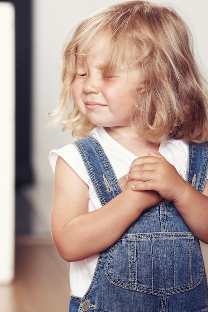 Gratis foto portret van een boos meisje in denim overalls, staande in een studio.