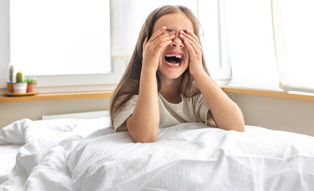 Portret van een charmant klein meisje in bed vroeg in de ochtend