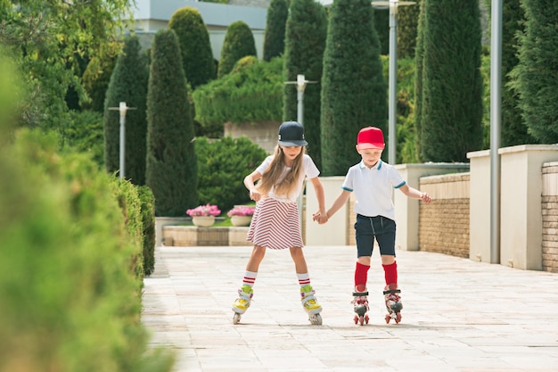 Portret van een charmante tienerpaar samen schaatsen op rolschaatsen in het park.