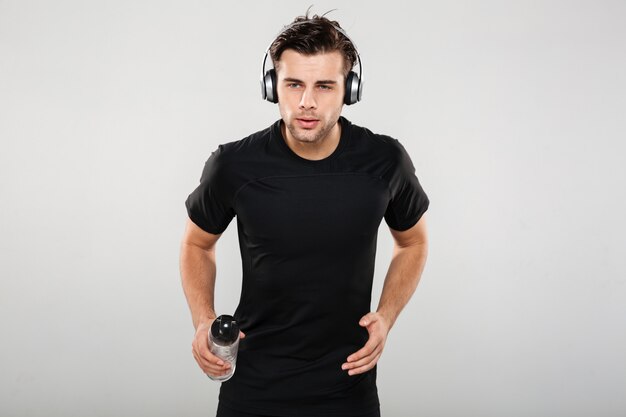 Portret van een fit jonge sportman luisteren naar muziek