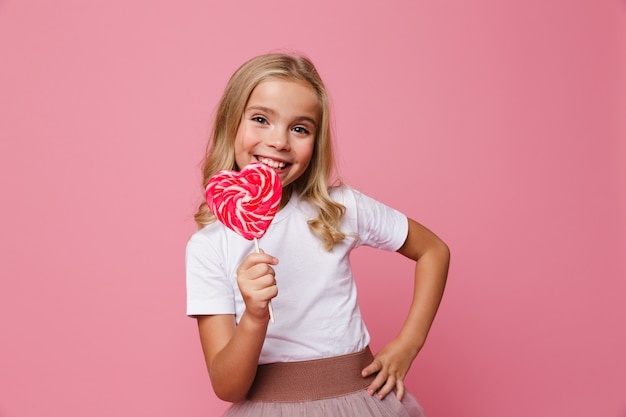 Portret van een gelukkig hart gevormde lolly van de meisjeholding