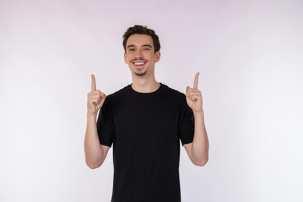 Portret van een gelukkig lachende jonge man die duimen omhoog gebaar toont en naar de camera kijkt op geïsoleerde over witte achtergrond