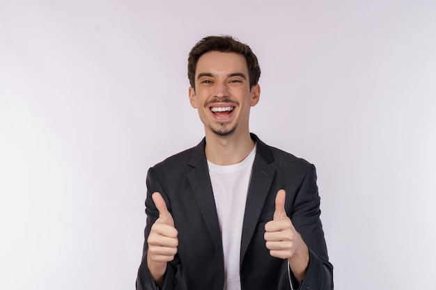 Portret van een gelukkig lachende jonge zakenman die duimen omhoog gebaar toont op geïsoleerde over witte achtergrond