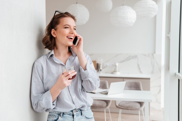 Portret van een gelukkig opgewonden vrouw praten op mobiele telefoon