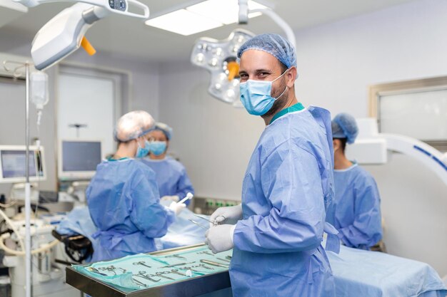 Portret van een gelukkige chirurg die in de operatiekamer staat, klaar om aan een patiënt te werken