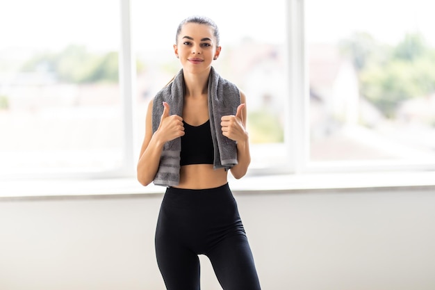 Portret van een gelukkige fitness vrouw met handdoek geïsoleerd op een witte achtergrond