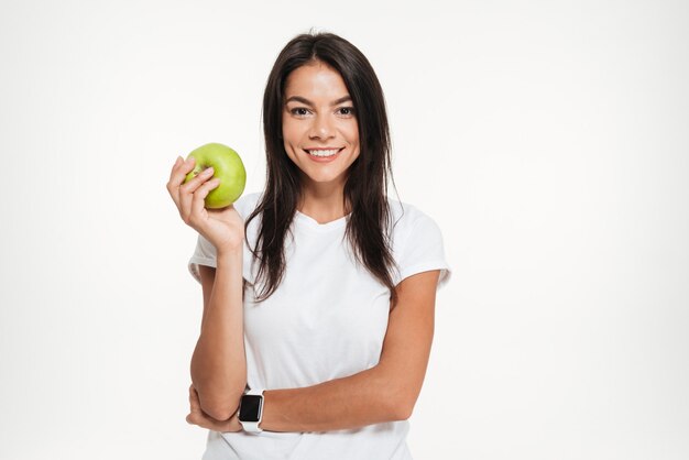 Portret van een gelukkige geschikte vrouw die groene appel houdt