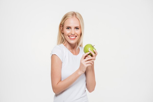 Portret van een gelukkige gezonde vrouw die groene appel houdt