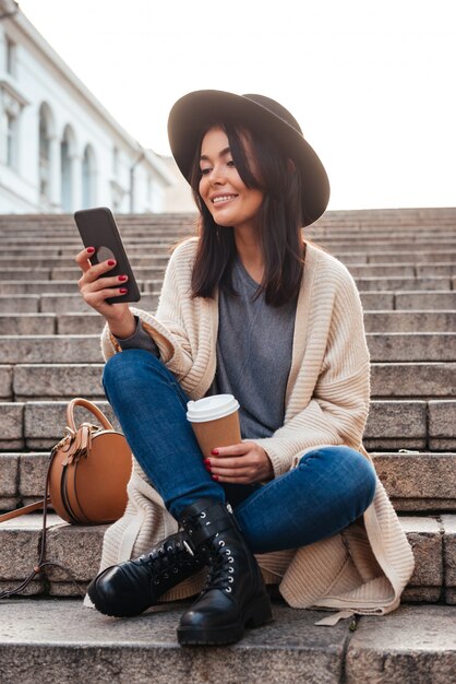 Portret van een gelukkige glimlachende vrouw die op mobiele telefoon texting