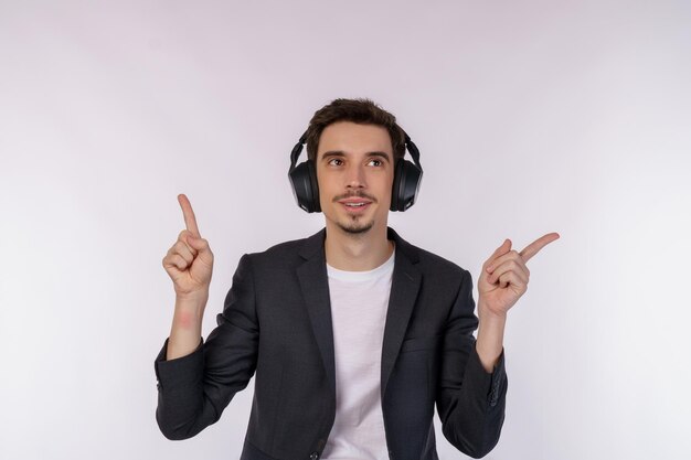 Portret van een gelukkige jonge man die een koptelefoon draagt en geniet van muziek op een witte achtergrond