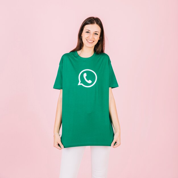 Portret van een gelukkige jonge vrouw in groene whatsapp t-shirt