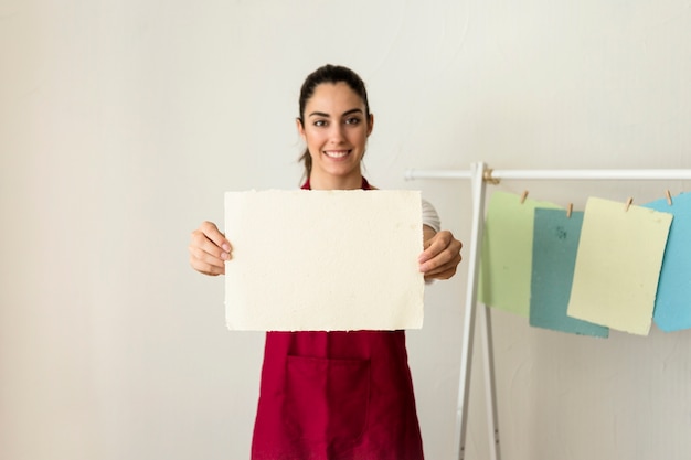Portret van een gelukkige jonge vrouw met handgeschept papier