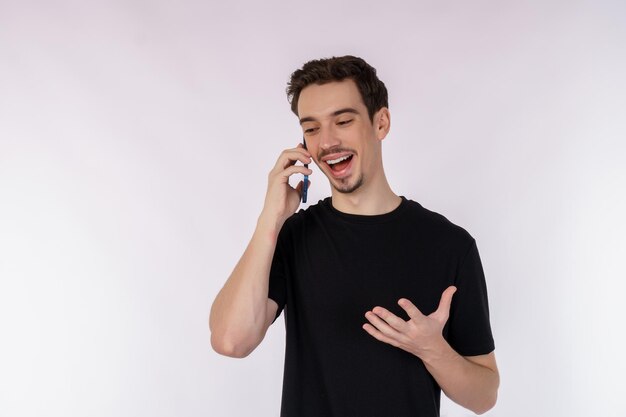 Portret van een gelukkige knappe zakenman die via de mobiele telefoon praat en geïsoleerd staat op een witte achtergrond