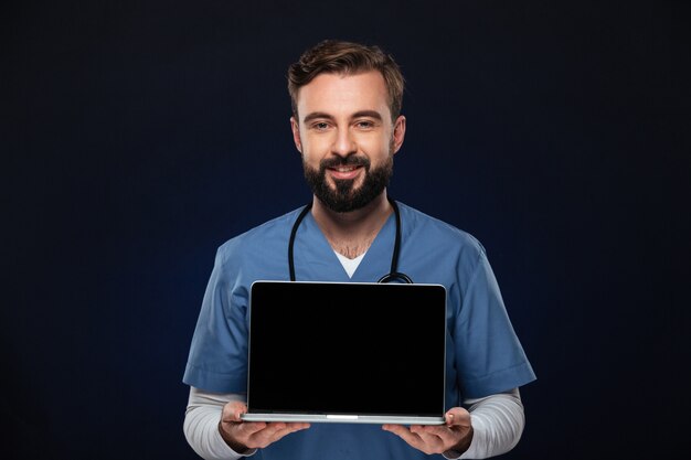 Portret van een gelukkige mannelijke arts gekleed in eenvormig