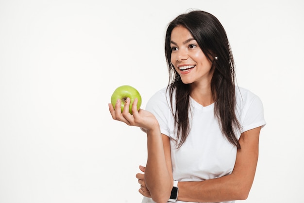 Portret van een gelukkige mooie vrouw die groene appel houdt