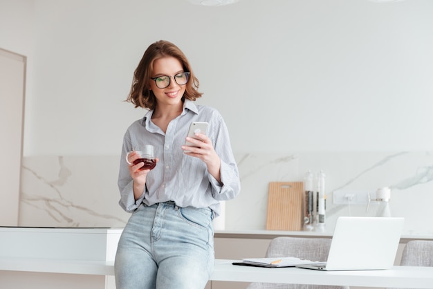 Portret van een gelukkige vrouw die mobiele telefoon met behulp van