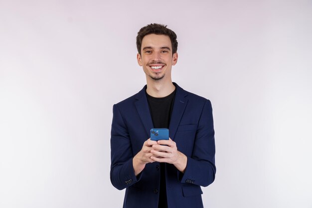 Portret van een gelukkige zakenman die smartphone op witte achtergrond gebruikt